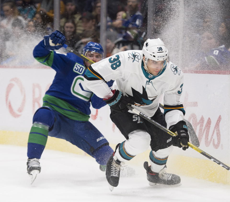 Vancouver Canucks left wing Tanner Pearson (70) fights for control of the puck with San Jose Sharks defenceman Mario Ferraro (38) during the third period of an NHL hockey game in Vancouver, British Columbia, Saturday, Jan. 18, 2020. (Jonathan Hayward/The Canadian Press via AP)