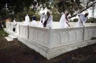 Shi'ite Muslim pilgrims from India clean a marble enclosure marking a shrine, located on the grounds of Barzilai Medical Center in the coastal town of Ashkelon February 8, 2015. REUTERS/Amir Cohen