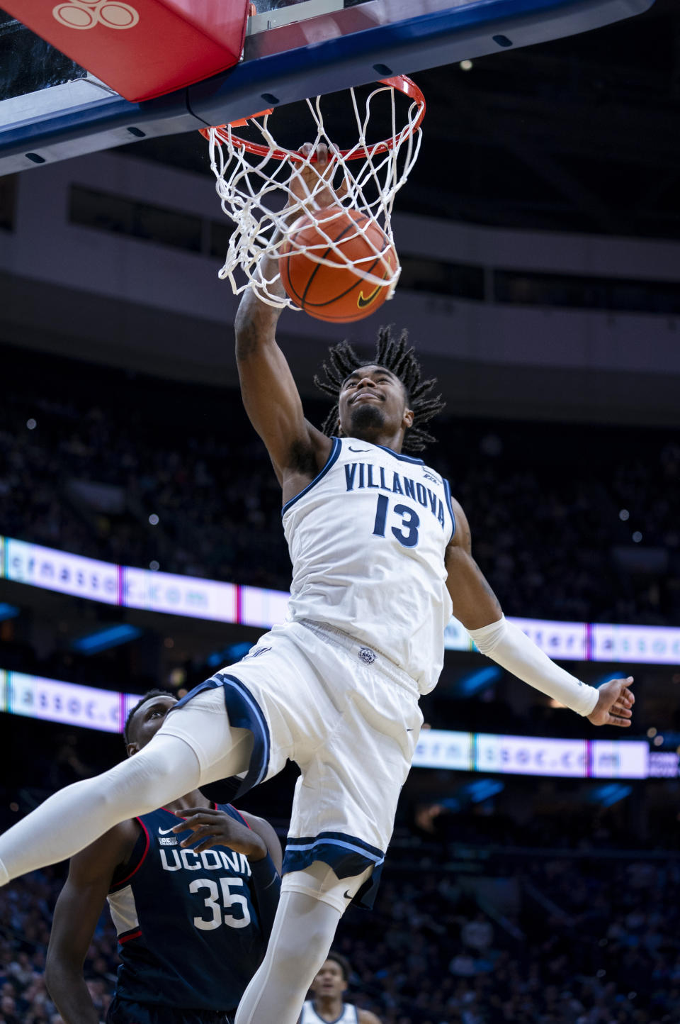 Villanova's Hakim Hart dunks as UConn's Samson Johnson watches during the first half of an NCAA college basketball game Saturday, Jan. 20, 2024, in Philadelphia. (AP Photo/Chris Szagola)