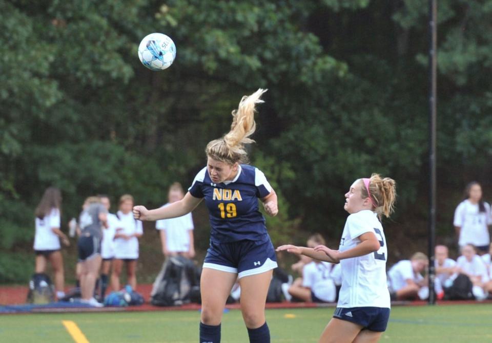 Notre Dame Academy's Caroline Sacco, left, heads the ball as Cohasset's Ava Carcio, right, moves in during girls high school soccer at Notre Dame Academy in Hingham, Wednesday, Sept. 14. 2022.