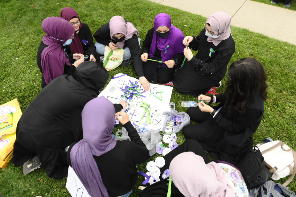 <p>Students make ribbons at a vigil outside the London Muslim Mosque for the victims of the deadly vehicle attack on five members of the Canadian Muslim community in London, Ont., on Tuesday, June 8, 2021. Four of the members of the family died and one is in critical condition. Police have charged a London man with four counts of murder and one count of attempted murder. THE CANADIAN PRESS/Nathan Denette</p> 