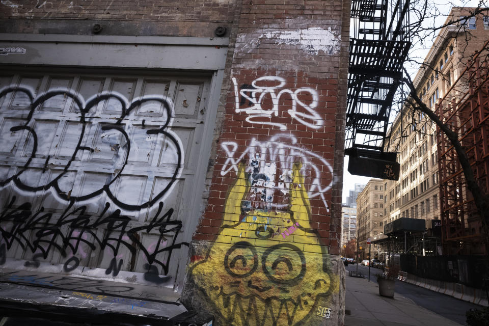 A building, right, that has been chosen by Google as part of its expansion plans is near a graffiti-covered wall, Monday, Dec. 17, 2018, in New York. Google is spending more than $1 billion on a new campus along the Hudson River that will allow it to double the number of people it already employs here. (AP Photo/Mark Lennihan)