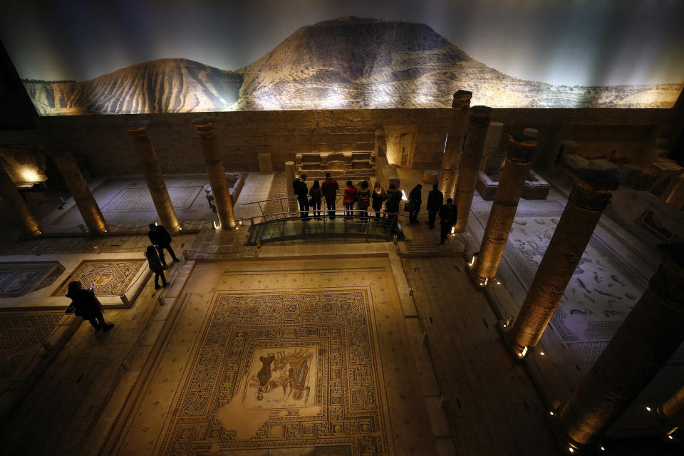 People visit the main exhibition hall of Zeugma Mosaic Museum, in Gaziantep, Turkey, Saturday, Dec. 8, 2018. A display of Roman-era mosaics that were part of a U.S. university's art collection and were returned to Turkey, more than half a century after looters smuggled them out, opened at the museum. Ohio's Bowling Green State University bought the 12 mosaics from a New York gallery in 1965. Turkish and Bowling Green officials agreed to their return in May 2018. (AP Photo/Emrah Gurel)