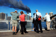 <p>Peatones en el muelle de Brooklyn, Nueva York, observan desde el otro lado del río mientras se incendia el World Trade Center. Tomada el 11 de septiembre, 2001 justo después de los ataques. (Photo: Henny Ray Abrams/AFP/Getty Images)</p>