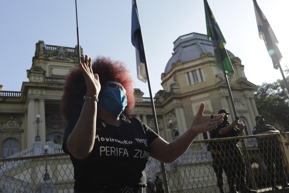 A woman protests against crimes committed by the police against black people in the favelas, outside the Rio de Janeiro's state government, Brazil, Sunday, May 31, 2020. The protest, called "Black lives matter," was interrupted when police used tear gas to disperse people. "I can't breathe", said some of the demonstrators, alluding to the George Floyd's death. (AP Photo/Silvia Izquierdo)