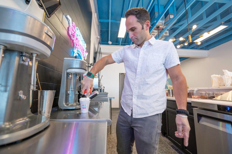 Shiver & Shake owner Andrew Diaz adds whipped cream to a milkshake on Friday, May 24, 2024.