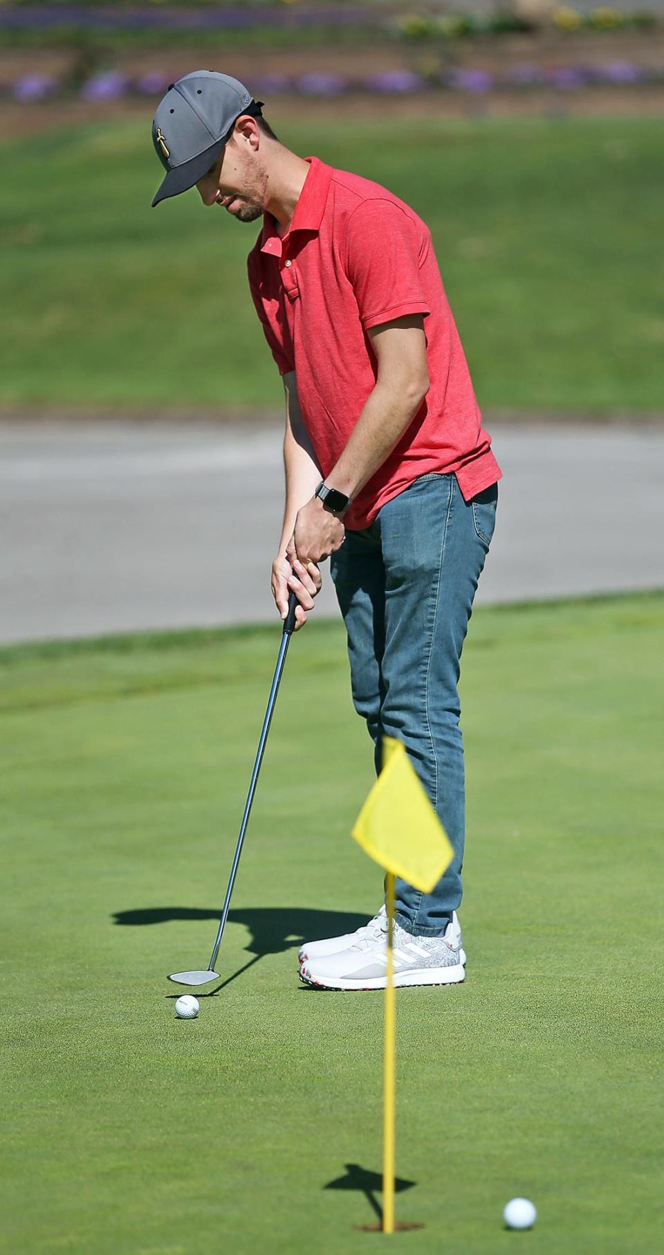 Jeremy Gaia, an intellectually disabled man from Chesterland, putts on the practice green at Firestone Country Club on Tuesday.