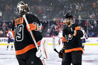 Philadelphia Flyers' Claude Giroux, right, high-fives Carter Hart after Giroux scored a goal during the first period of an NHL hockey game against the Washington Capitals, Saturday, Feb. 26, 2022, in Philadelphia. (AP Photo/Derik Hamilton)