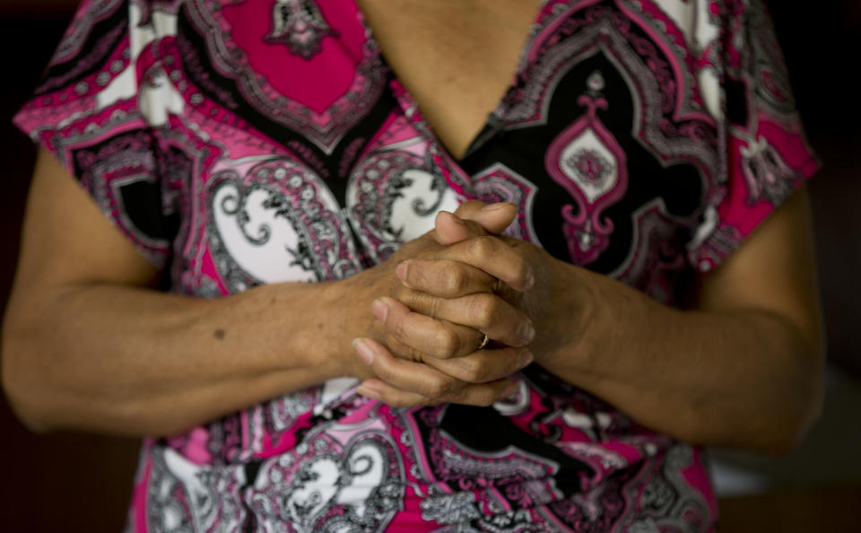 In this Feb. 5, 2014, photo, Maria Gonzalez clasps her hands during an interview with The Associated Press inside his home in Yautepec, Mexico. In 2012, her son Cesar, a 33-year-old architect and engineer, was kidnapped as he drove through Cuernavaca to visit his family in Yautepec. The family got together $10,000 and left it in packets of $2,000 in a cereal box in Cuernavaca. Five days later he was found dead in the trunk of his car. (AP Photo/Eduardo Verdugo)