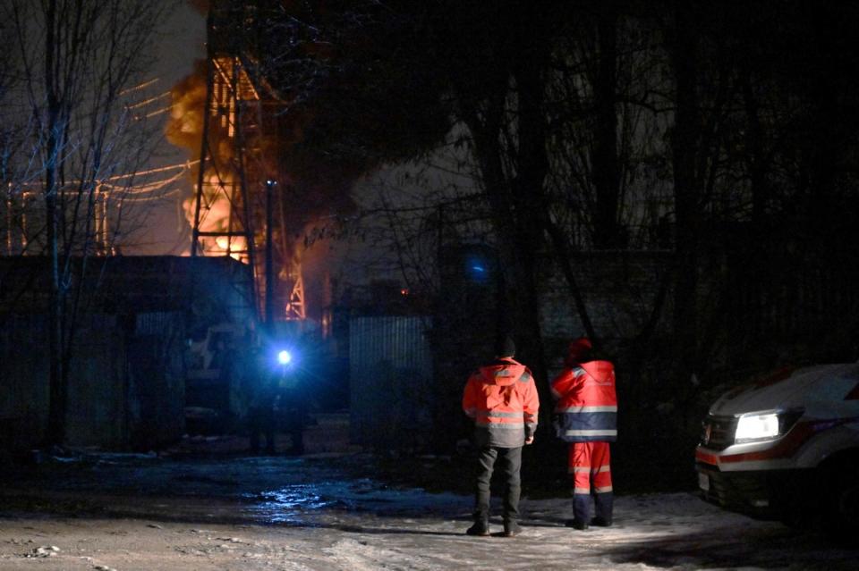Des sauveteurs tentent d'éteindre une infrastructure électrique critique en feu après une attaque de drone à Kyiv, (AFP via Getty Images)
