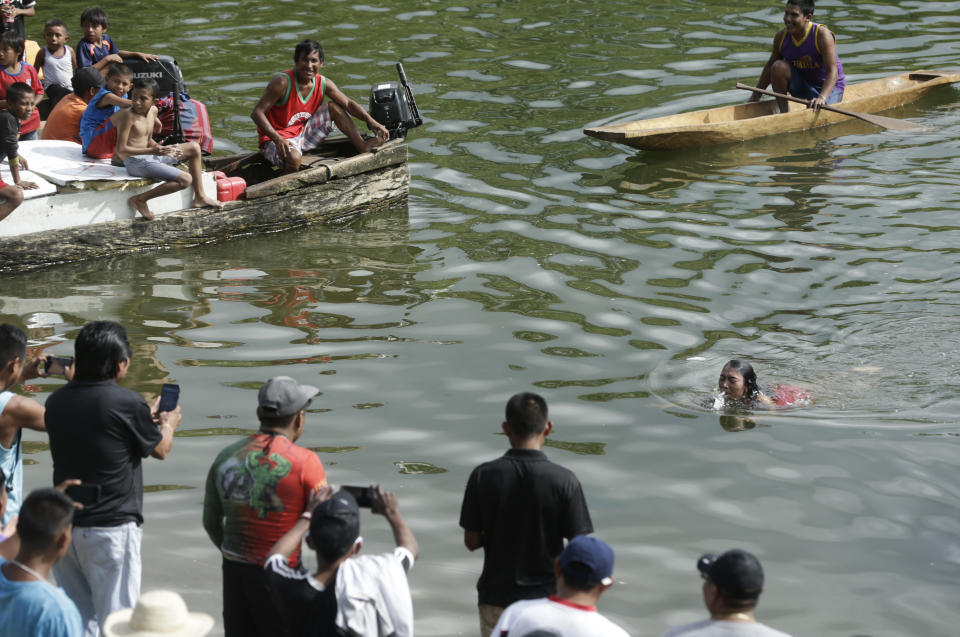 In this Nov. 25, 2018 photo, a Guna woman competes in the swimming event of the second edition of the Panamanian indigenous games on lake Bayano, Panama. Sixty athletes were selected to compete in the upcoming world indigenous games. (AP Photo/Arnulfo Franco)