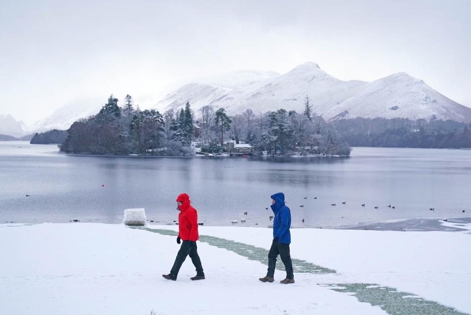 People walking in snowy conditions in Crow Park at Derwent Water in Keswick, Cumbria. Much of Britain is facing another day of cold temperatures and travel disruption after overnight lows dropped below freezing for the bulk of the country. A 