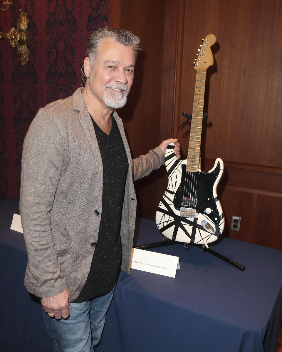 FILE - Musician Eddie Van Halen poses with his "Frankenstein guitar" before the "What It Means to Be American" program at the Smithsonian's National Museum of American History in Washington on Feb. 12, 2015. Van Halen, who had battled cancer, died Tuesday, Oct. 6, 2020. He was 65. (Photo by Owen Sweeney/Invision/AP, File)