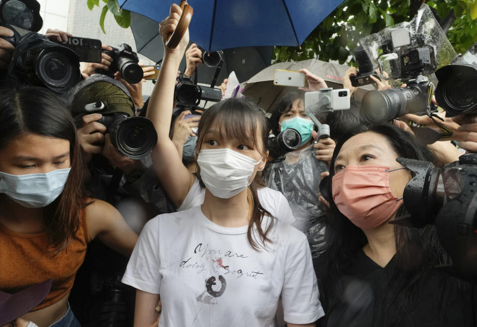 FILE- Agnes Chow, center, a prominent pro-democracy activist who was sentenced to jail for her role in an unauthorized protest, is released in Hong Kong Saturday, June 12, 2021. One of Hong Kong’s best-known pro-democracy activists, who moved to Canada to pursue further studies, said she would not return to the city to meet her bail conditions, becoming the latest politician to flee Hong Kong under Beijing's crackdown on dissidents.(AP Photo/Vincent Yu, File)