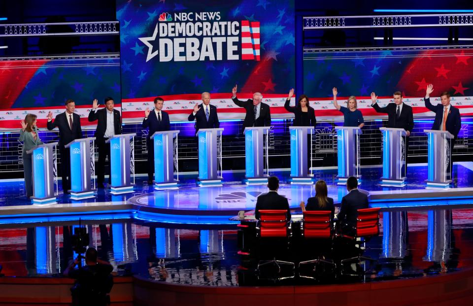 In this June 27, 2019 photo, Democratic presidential candidates, author Marianne Williamson, former Colorado Gov. John Hickenlooper, entrepreneur Andrew Yang, South Bend Mayor Pete Buttigieg, former Vice President Joe Biden, Sen. Bernie Sanders, I-Vt., Sen. Kamala Harris, D-Calif., Sen. Kirsten Gillibrand, D-N.Y., Colorado Sen. Michael Bennet, and Rep. Eric Swalwell, D-Calif., raise their hands when asked if they would provide healthcare for undocumented immigrants, during the Democratic primary debate hosted by NBC News at the Adrienne Arsht Center for the Performing Arts in Miami. (AP Photo/Wilfredo Lee) ORG XMIT: WX401