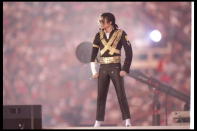 <div class="caption-credit"> Photo by: Getty Images/George Rose</div>Fireworks announced Michael Jackson's 1993 arrival to the halftime stage, where he stood motionless for over a minute in his gold-plated military-style jacket, cropped black pants and signature Ray Ban aviator sunglasses, which he then whipped off and tossed before busting out for a "Heal the World" themed performance. <br>