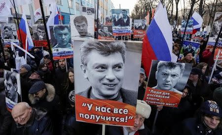 Opposition supporters hold portraits of Kremlin critic Boris Nemtsov during a rally to mark the anniversary of his murder in Moscow, Russia, February 26, 2017. The placard reads 'We can do it'. REUTERS/Tatyana Makeyeva