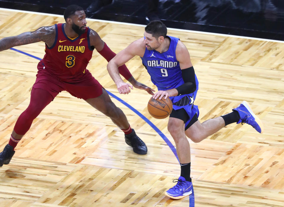 Jan 6, 2021; Orlando, Florida, USA; Orlando Magic center Nikola Vucevic (9) drives to the basket as Cleveland Cavaliers center Andre Drummond (3) defends during the first quarter at Amway Center. 