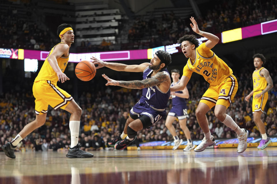 Northwestern guard Boo Buie, center, passes as Minnesota forwards Dawson Garcia, left, and Nick Martinelli (2) defend during the second half of an NCAA college basketball game, Saturday, Feb. 3, 2024, in Minneapolis. (AP Photo/Abbie Parr)