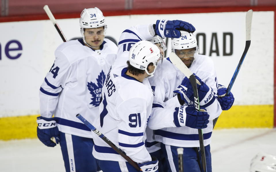 Toronto Maple Leafs' Wayne Simmonds, right, celebrates his goal against the Calgary Flames with teammates Auston Matthews, left, and John Tavares during second-period NHL hockey game action in Calgary, Alberta, Sunday, Jan. 24, 2021. (Jeff McIntosh/The Canadian Press via AP)