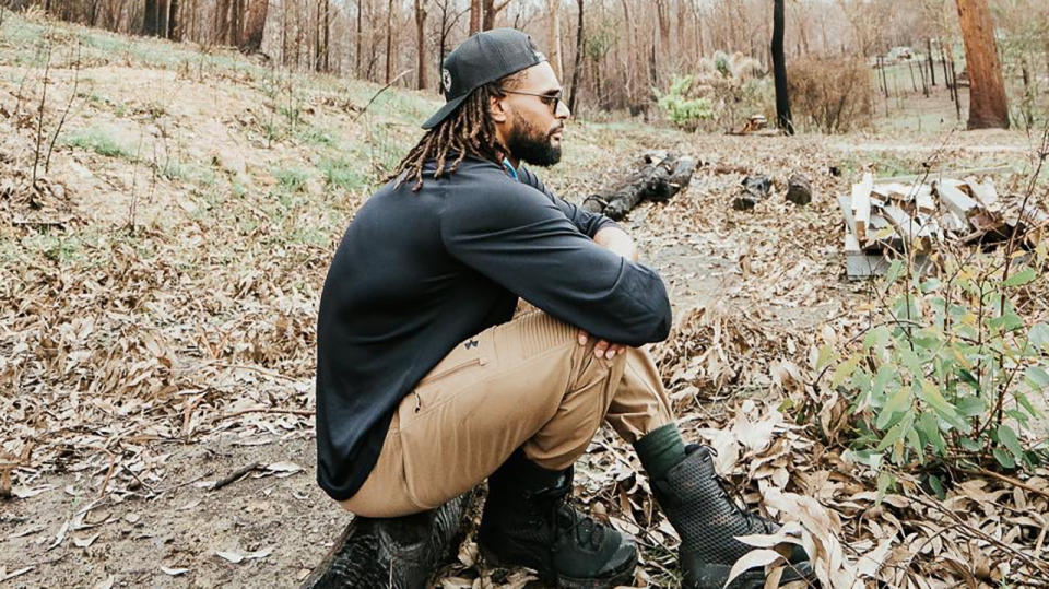 Australian NBA star Patty Mills is pictured surveying the scene of a bushfire during a visit in February.