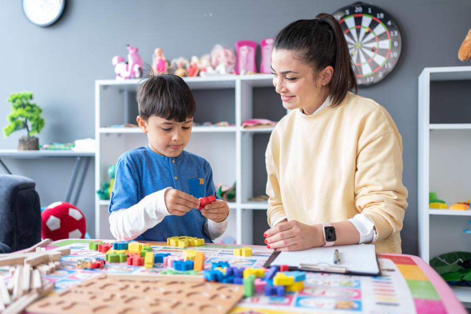 A counselor works with a young child who is playing with building blocks