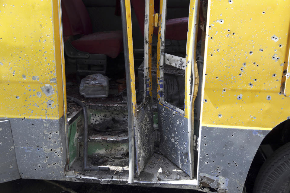 A damaged bus sits at the scene of an explosion in Kabul, Afghanistan, Sunday, June 2, 2019. Afghan officials say there have been three explosions in the capital, Kabul, including a sticky bomb attached to the bus carrying university students. (AP Photo/Rahmat Gul)