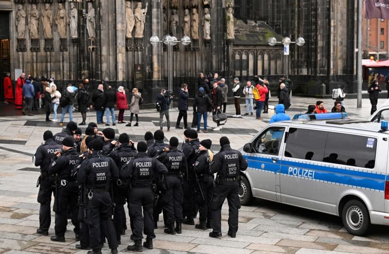 Police officers patrol the entrance to Cologne Cathedral on Christmas Day. Due to indications of a planned Islamist attack, the police have stepped up security measures. Roberto Pfeil/dpa