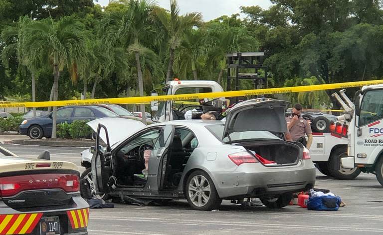 Pictured is police holding their noses as they search the silver Acura. 