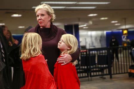 Members of a family, who said they were on Delta flight 1086 which arrived from Atlanta, embrace at the baggage claim area in Terminal D of LaGuardia Airport while awaiting their transport in New York March 5, 2015. REUTERS/Shannon Stapleton