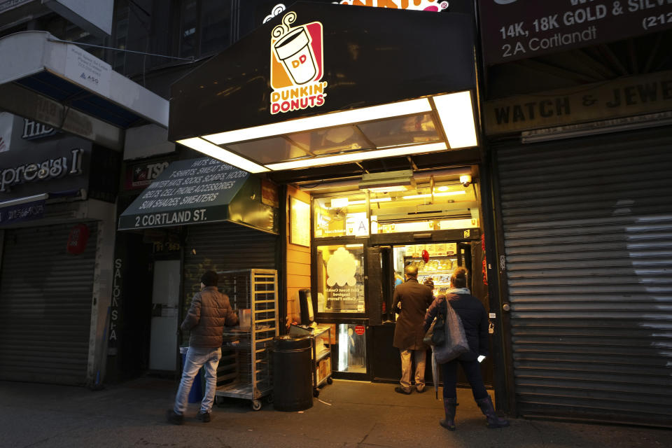 In this Wednesday, Feb. 6, 2019, photo customers arrive before dawn at a Dunkin' Donuts in New York. Dunkin' Brands Group Inc. reports financial results Thursday, Feb. 7. (AP Photo/Mark Lennihan)