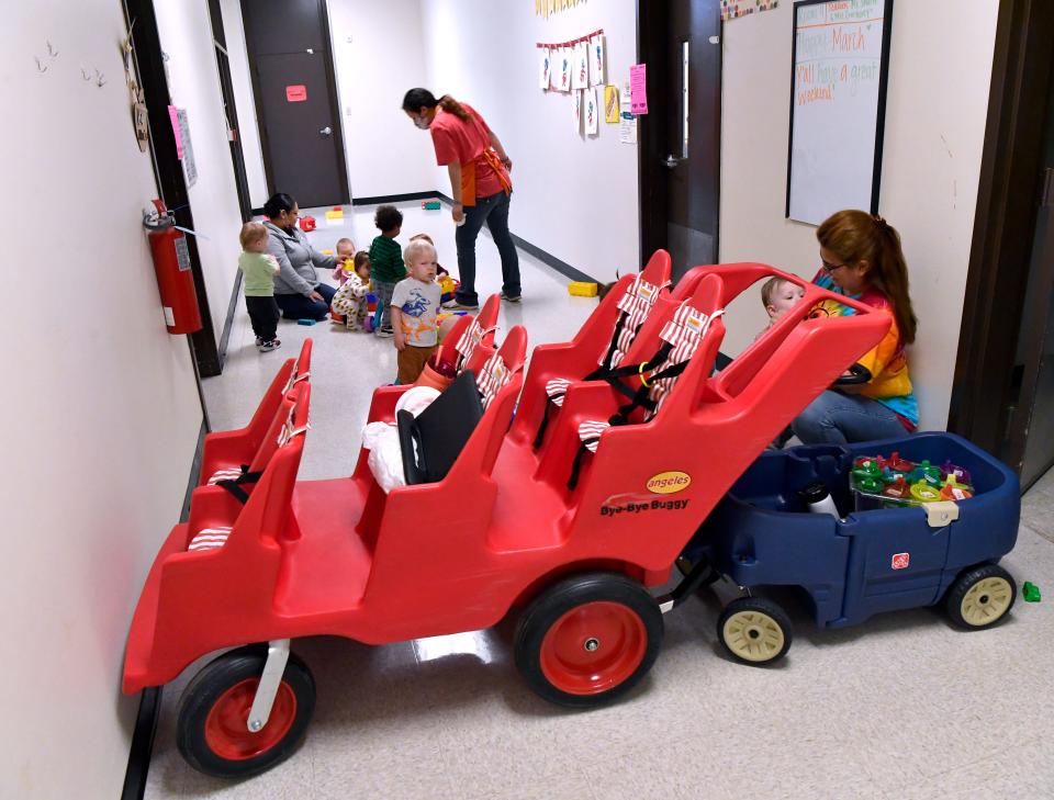 Chloe Melchor (center) works with other instructors at the Orange Street Day Nursery of Abilene. They improvised a play area in the former elementary school’s hallway to create a play area for their 12-18 month-old charges.