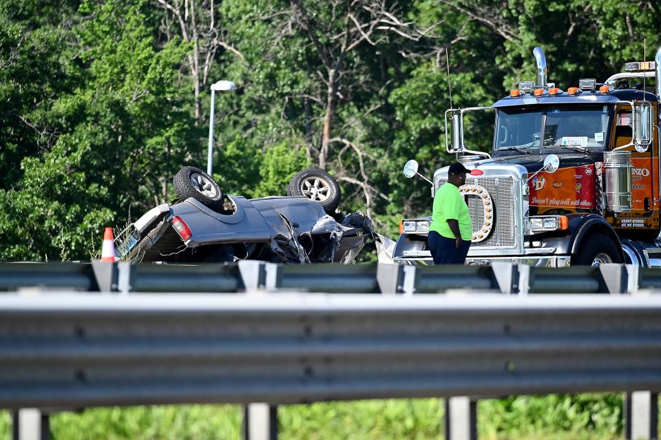 A tow truck crew works to remove a vehicle from a highway guardrail after a fatal crash Saturday on Interstate 290 eastbound in Worcester.