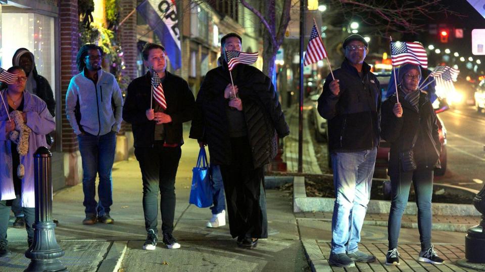 Solemn onlookers lined North Street to witness the return of Staff Sgt. Jake Galliher, Friday, Dec. 15, 2023 in Pittsfield, Mass. (Ben Garver/The Berkshire Eagle via AP)