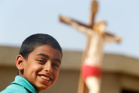 A Christian boy who left from Al-Arish city North Sinai’s Governorate capital after the escalation of a campaign targeting Christians by Islamic State militants last week, smiles near at scale model of Christ after arriving at the Saint Church in Ismailia, northeast of Cairo, Egypt February 27, 2017. Picture taken February 27, 2017. REUTERS/Amr Abdallah Dalsh