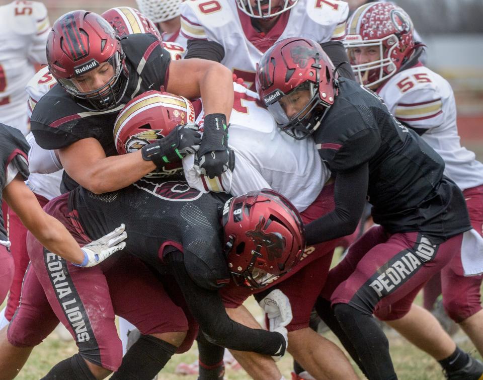 The Peoria High defense brings down Morris running back Sam Reddinger in the first half of their Class 5A football state semifinal Saturday, Nov. 19, 2022 at Peoria Stadium.