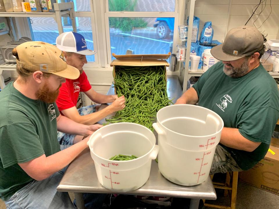 Staff and co-owner Johnny Cleary snap fresh green beans during a recent lunch shift at O’Steen’s Restaurant. The popular dining spot sources local vegetables for their homestyle menu.