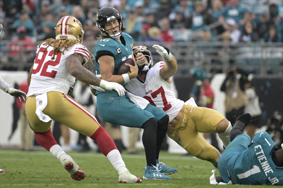 Jacksonville Jaguars quarterback Trevor Lawrence, center, is sacked by San Francisco 49ers defensive end Nick Bosa (97) during the second half of an NFL football game, Sunday, Nov. 12, 2023, in Jacksonville, Fla. (AP Photo/Phelan M. Ebenhack)