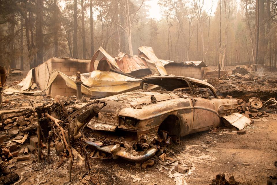 A burned classic car sits among the smoldering remains of a home during the Dixie fire in the Indian Falls neighborhood of unincorporated Plumas County, California on July 26, 2021. (Josh Edelson/AFP via Getty Images)
