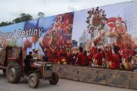 Pakistani labourers drive past a welcome bilboard ahead of the visit by Chinese President Xi Jinping in Islamabad on April 19, 2015