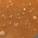 Esta vista aumentada del suelo marciano, cerca del lugar de aterrizaje del Opportunity en el Meridiani Planum, muestra los granos esparcidos de una fina capa de arena. La imagen fue captada por la cámara microscópica de la nave robot y más o menos se aproxima al color que apreciaría un ojo humano.