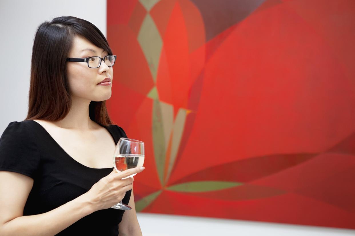 young woman looking at wall paintings in art gallery