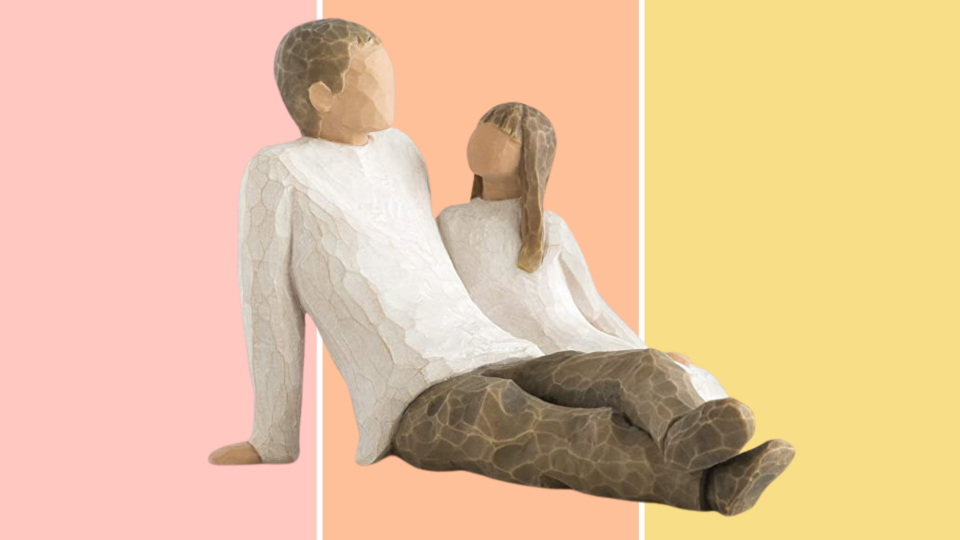 The sculpture captures a father and daughter sitting back in a peaceful moment.