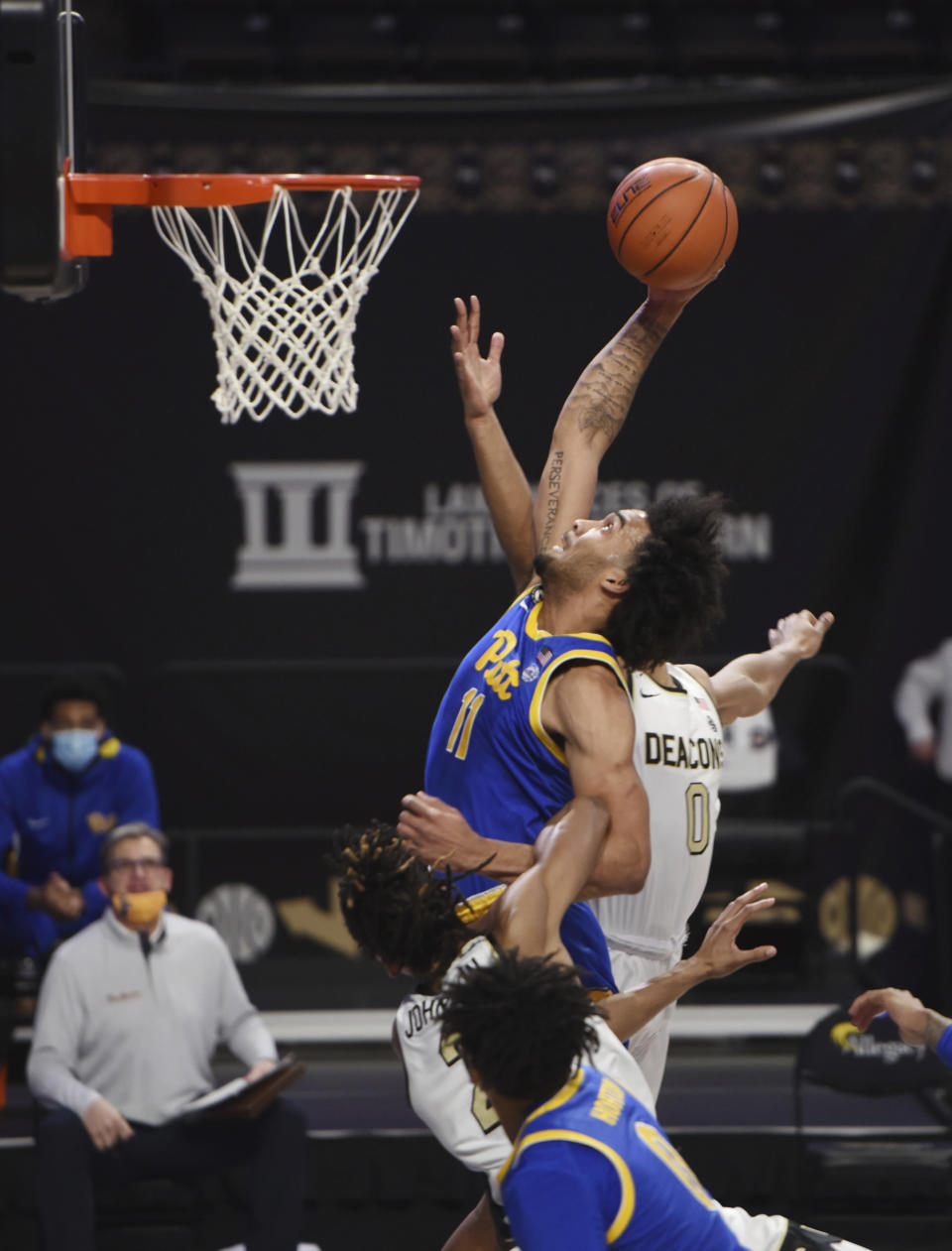 Pittburgh's Justin Champagnie drives to the basket past Wake Forest Jalen Johnson (2) and Jahcobi Neath (0) during an NCAA college basketball game Saturday, Jan. 23, 2021, in Winston-Salem, N.C. (Walt Unks/The Winston-Salem Journal via AP)