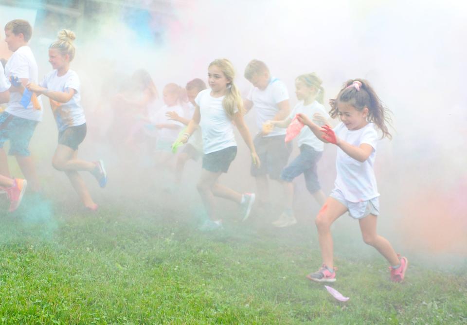 Children run through colored powder at the start of the Carnation Youth Color Run on Tuesday, Aug. 9, 2022, at Alliance First Christian Church in Washington Township.
