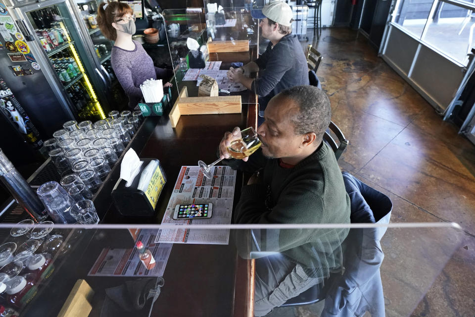 Darrell Boyd sips a glass of wine at the Winking Lizard Tavern, Monday, Nov. 16, 2020, in Beachwood, Ohio. Ohio Governor Mike DeWine issued a new health warning Sunday to limit mass gatherings. (AP Photo/Tony Dejak)