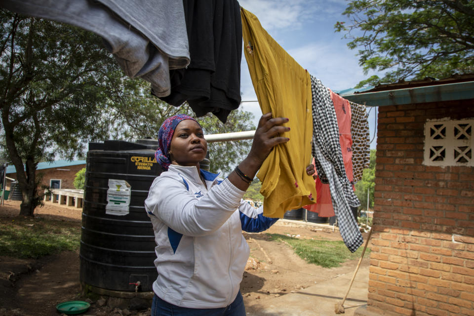 A woman who was evacuated from Libya to Rwanda hangs washed clothes in the Gashora transit center for refugees and asylum-seekers, in the Bugesera district of Rwanda Friday, June 10, 2022. As Britain plans to send its first group of asylum-seekers to Rwanda amid outcries and legal challenges, some who came there from Libya under earlier arrangements with the United Nations say the new arrivals can expect a difficult time ahead. (AP Photo)