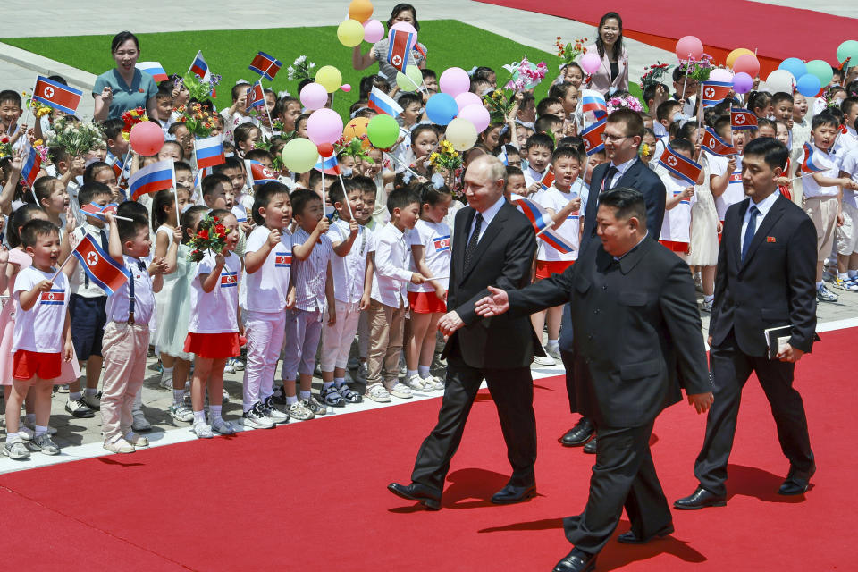 El presidente de Rusia, Vladímir Putin (izquierda), y el líder de Corea del Norte, Kim Jong Un (delante, derecha), durante la ceremonia oficial de bienvenida al mandatario, en la plaza Kim Il Sung de Pyongyang, Corea del Norte, el 19 de junio de 2024. (Vladimir Smirnov, Sputnik, Kremlin Pool Foto vía AP)