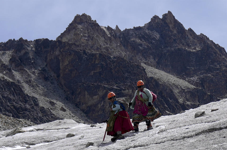 Cholita climbers Suibel Gonzales, left, and her mother Lidia Huayllas descend the Huayna Potosi mountain, near El Alto, Bolivia, Sunday, Nov. 5, 2023. In 2015, Huayllas conquered the peak with the group of Cholitas climbers, Aymara women who started out as cooks and who for eight years have dedicated themselves to climbing mountains with their typical clothing of colorful skirts and blankets, as guides for tourists who want to cross off having climbed a glacier from their list of achievements. (AP Photo/Juan Karita)