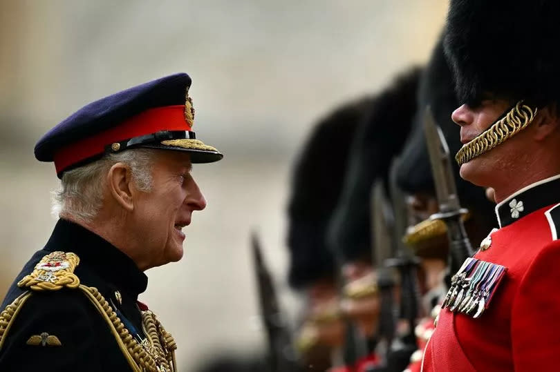 King Charles III, Colonel-in-Chief of the Household Division, presents new colours to be trooped in the Trooping of the Colour at the King's official Birthday Parade in London on Saturday June 15